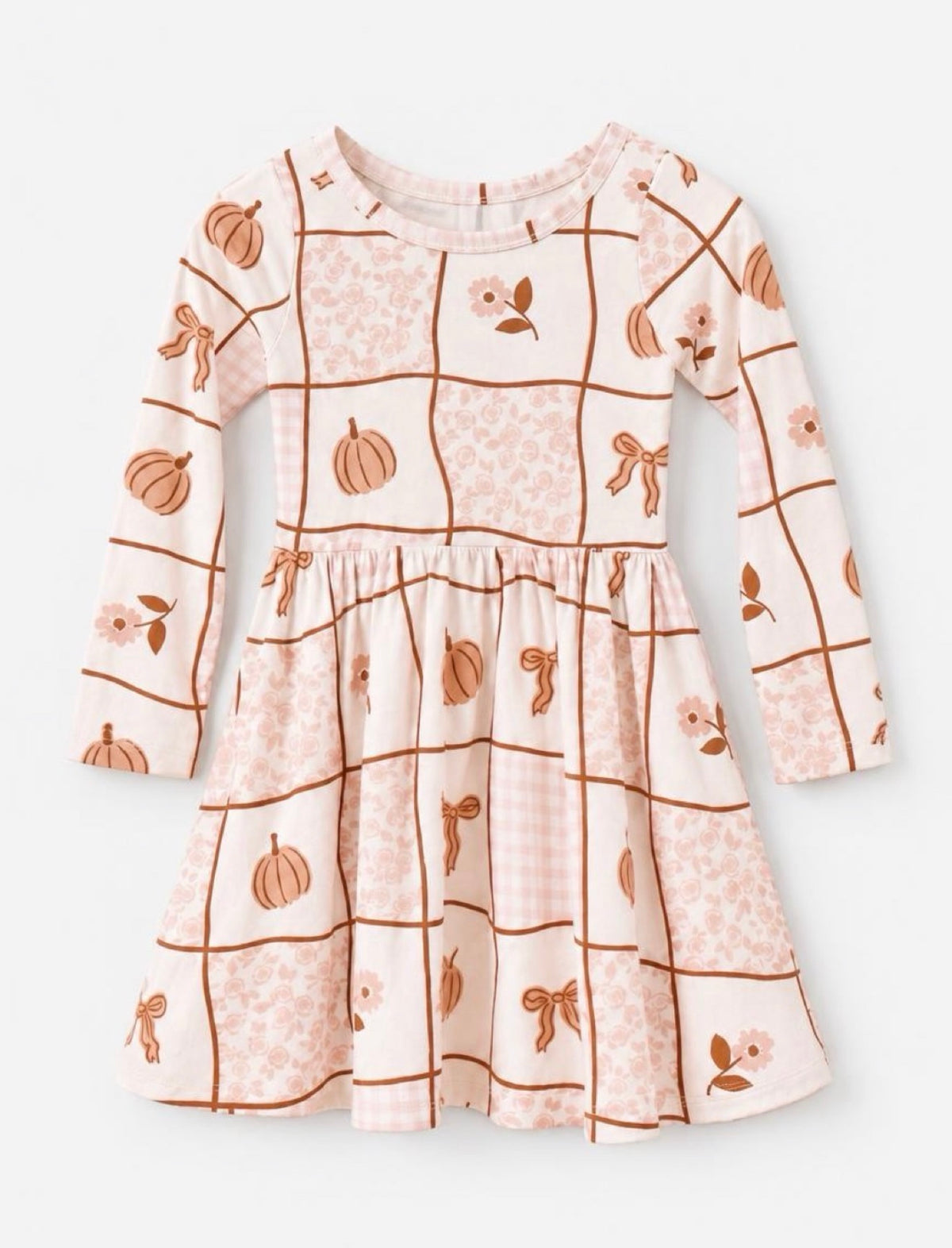 A long sleeve cream, brown and tan girls’ twirl dress with a patchwork pattern with pumpkins bows and tiny flowers.